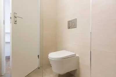 a bathroom with a toilet and a glass shower at Sea Studio in Quarteira