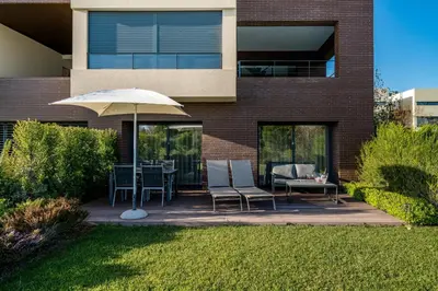 a patio with a table and chairs and an umbrella at Vilamoura Charming Apartment by Intiholidays in Vilamoura
