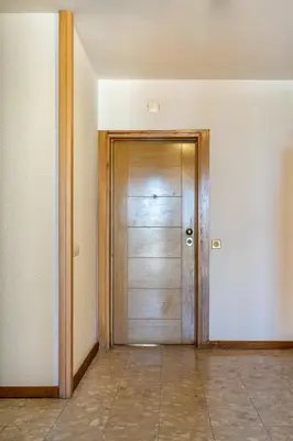 a wooden door in a room with a tile floor at Edifício Algarve in Quarteira