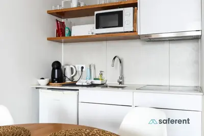 a kitchen with a sink and a microwave at Edifício Algarve in Quarteira