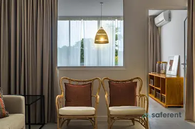 a living room with two chairs and a window at Edifício Algarve in Quarteira