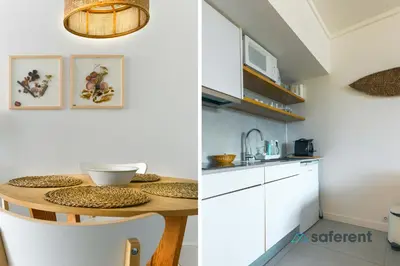 a kitchen with white cabinets and a wooden table at Edifício Algarve in Quarteira