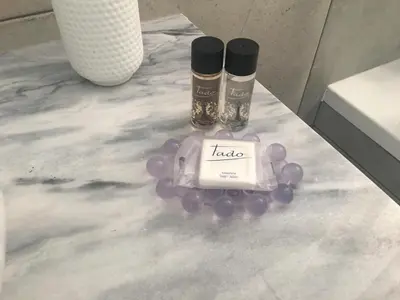 a table with two bottles of lipstick and purple grapes at Villa Zen - beautiful private pool-heating option, hot tub, beautiful garden in Albufeira