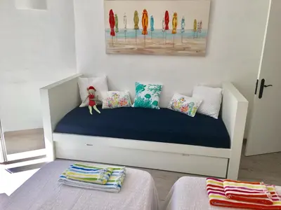 a childs bedroom with a white bed and a painting at Villa Zen - beautiful private pool-heating option, hot tub, beautiful garden in Albufeira