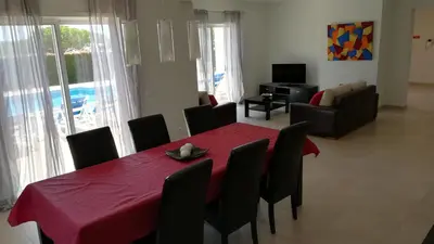 a dining room with a red table and chairs at Villa 48 in Quarteira