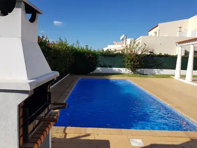 a swimming pool in a yard next to a house at Villa 300m from Beach - By Algarkasa in Albufeira