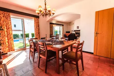 a dining room with a wooden table and chairs at Villa 300m from Beach - By Algarkasa in Albufeira