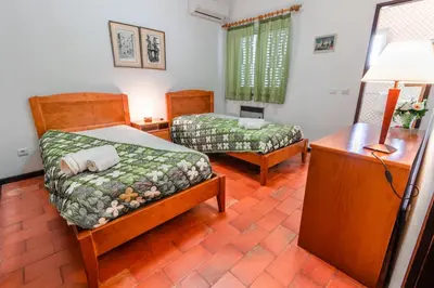 a room with two beds and a table and a lamp at Villa 300m from Beach - By Algarkasa in Albufeira