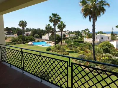 a balcony with a view of a golf course and palm trees at Apartment Coelha Beach - Pool - Free Wi-Fi - Air Con in Albufeira