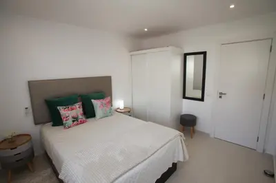 a bedroom with a bed with green and pink pillows at Apartamento A Palmeira in Albufeira