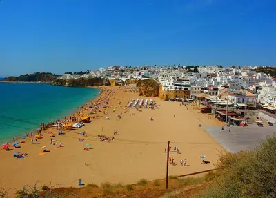 a group of people on a beach with the ocean at Apartamento A Palmeira in Albufeira