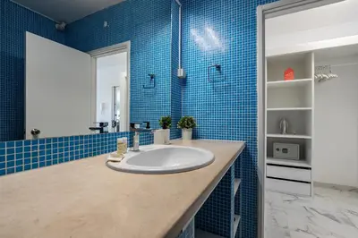 a bathroom with a sink and blue tiles at T0 Vilamoura Downtown in Vilamoura