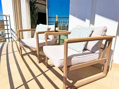 a pair of chairs and a table on a balcony at AlbufeiraOrada by Be Cherish in Albufeira