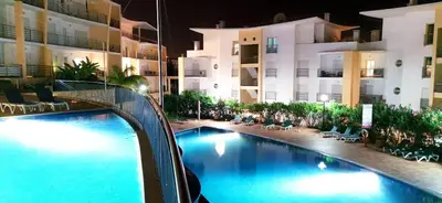 a swimming pool in front of a building at night at AlbufeiraOrada by Be Cherish in Albufeira