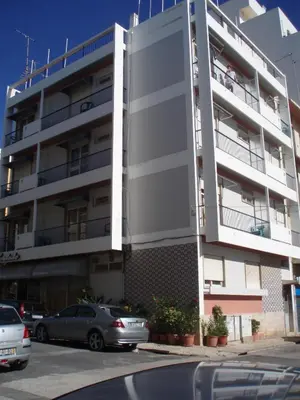 a white building with cars parked in front of it at Residencial Condado in Faro