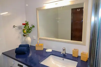 a bathroom with a blue sink and a mirror at Santa Eulalia Mar in Albufeira
