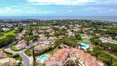 a group of chairs and umbrellas next to a pool at Vale do Lobo - Casa de La Rosa in Vale do Lobo