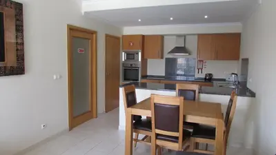 a kitchen with a table and chairs in a room at Vista das Ondas in Albufeira