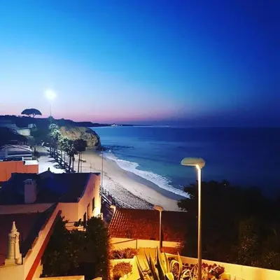 a view of a beach at night with a street light at Vista das Ondas in Albufeira
