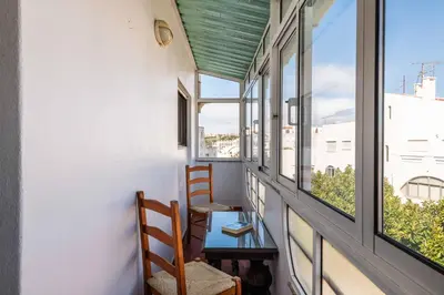 a balcony with two chairs and a glass table at Casa Cerro Branco in Albufeira