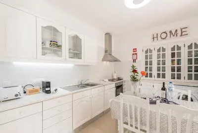 a white kitchen with white cabinets and a sink at Fisherman's Beach Home 2BR 2BA AC Wi-Fi in Albufeira