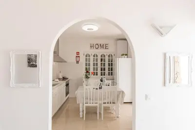 a white kitchen with a table and a white refrigerator at Fisherman's Beach Home 2BR 2BA AC Wi-Fi in Albufeira