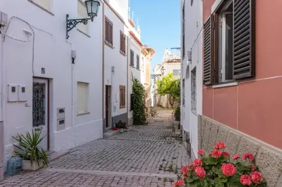 an alley in an old town with flowers at Fisherman's Beach Home 2BR 2BA AC Wi-Fi in Albufeira