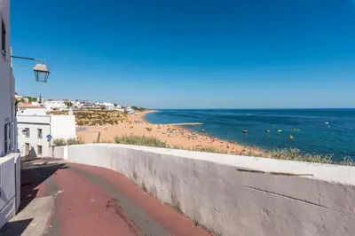 a view of a beach with the ocean and a wall at Fisherman's Beach Home 2BR 2BA AC Wi-Fi in Albufeira
