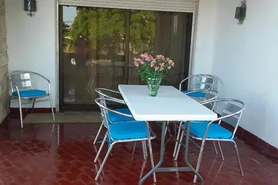 a table and chairs with a vase of flowers on it at Apartamento Sao Jose in Albufeira