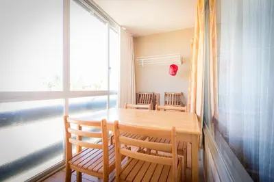 a dining room table with two chairs and a window at Apartments near Marina de Vilamoura in Quarteira