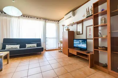 a living room with a blue couch and a tv at Apartments near Marina de Vilamoura in Quarteira