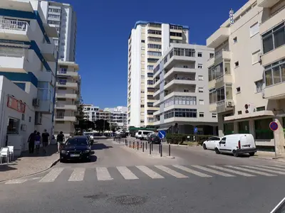 a city street with cars parked on the street at Torre Azul 11 Vista Panoramica in Quarteira