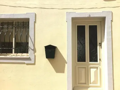 a yellow building with a door and a window at Yellow House - Checkinhome in Boliqueime