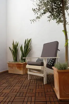 a white bench sitting in a room with plants at Yellow House - Checkinhome in Boliqueime