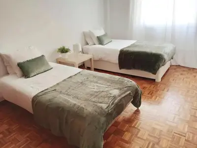 a bedroom with two beds and a couch at cosy2bedroomapartment in Loulé