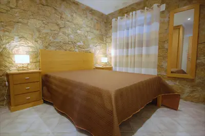 a bedroom with a bed and a stone wall at Vila Baltum - Free private parking - Wifi - Airco # by bedzy # in Albufeira