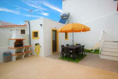 a patio with a table and an umbrella at Vila Baltum - Free private parking - Wifi - Airco # by bedzy # in Albufeira