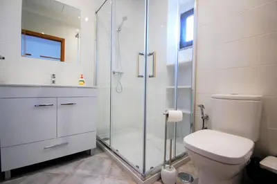 a white bathroom with a shower and a toilet at Vila Baltum - Free private parking - Wifi - Airco # by bedzy # in Albufeira