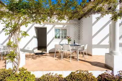 a patio with a table and chairs in front of a building at Exclusive Villa Toulouse with pool in Falesia Algarve in Albufeira