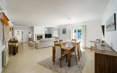 a dining room and living room with a table and chairs at Exclusive Villa Toulouse with pool in Falesia Algarve in Albufeira