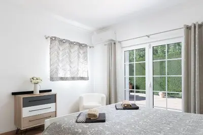 a white bedroom with a bed and a window at Exclusive Villa Toulouse with pool in Falesia Algarve in Albufeira