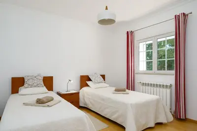 two beds in a white room with a window at Exclusive Villa Toulouse with pool in Falesia Algarve in Albufeira