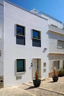 a white building with windows and plants in front of it at Casa Indigo- Perfect location & Sea View by DreamvillasAlbufeira in Albufeira