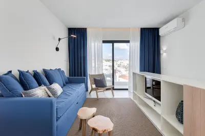a blue couch in a living room with a window at Casa Indigo- Perfect location & Sea View by DreamvillasAlbufeira in Albufeira