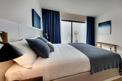 a bedroom with a large white bed with blue pillows at Casa Indigo- Perfect location & Sea View by DreamvillasAlbufeira in Albufeira