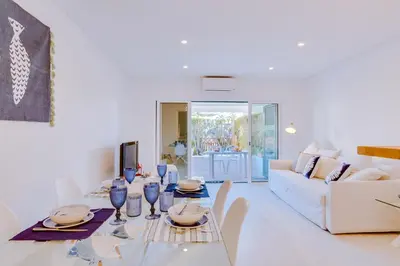 a white living room with a table and a white couch at Villa V1 Vale do Lobo Beach in Vale do Lobo