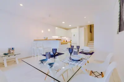 a dining room with a glass table and white chairs at Villa V1 Vale do Lobo Beach in Vale do Lobo