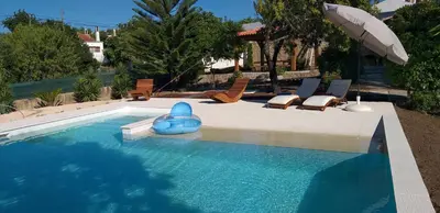 a swimming pool with lounge chairs and an umbrella at FIND Your Space Casa no Campo - Paderne - Albufeira - Piscina Privada - Aquecida a pedido in Paderne
