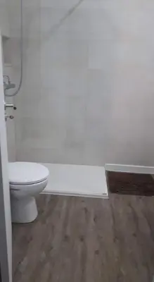 a bathroom with a white toilet and a wooden floor at Hello Chloé in Vilamoura