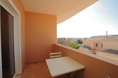 a small white table and chair on a balcony at Full private 300sqm Villa Jacuzzi Heated Pool Ideal & quiet location in Albufeira